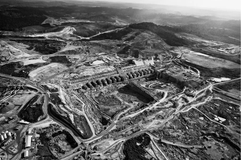 Vítězná fotografie v kategorii Dlouhodobý projekt. Letecký pohled z roku 2013 na stavbu přehrady Belo Monte na řece Xingu v Brazílii. Více než osmdesát procent vody v řece bylo odkloněno z jejího přirozeného toku na stavbu vodní elektrárny. Drastické snížení průtoku má nepříznivý vliv jak na životní prostředí, tak na domorodé komunity žijící v jejím okolí