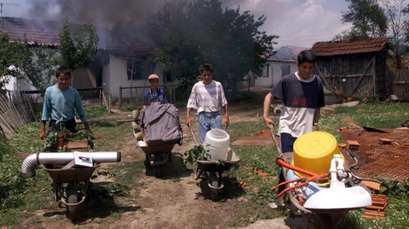 Albánci rabují opuštěný srbský dům v kosovském městě Vučitrn (20. 6. 1999)