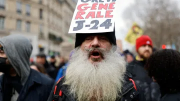 Protestující ve Francii drží transparent s nápisem Generální stávka J-24