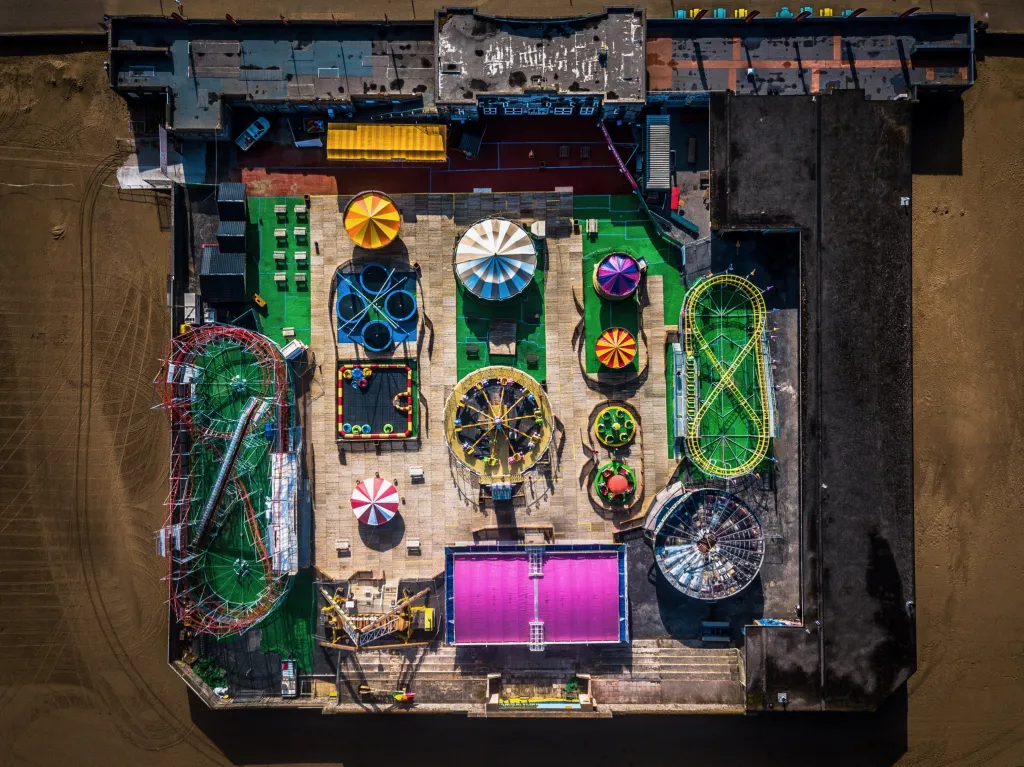 Obvodová deska nebo lunapark (kategorie Pouliční fotografie). Pohled z ptačí perspektivy vypadá jako detail obvodové desky, ale jde o časně ranní snímek zábavního areálu na pláži u města Weston Super Mare, Somerset (Anglie).