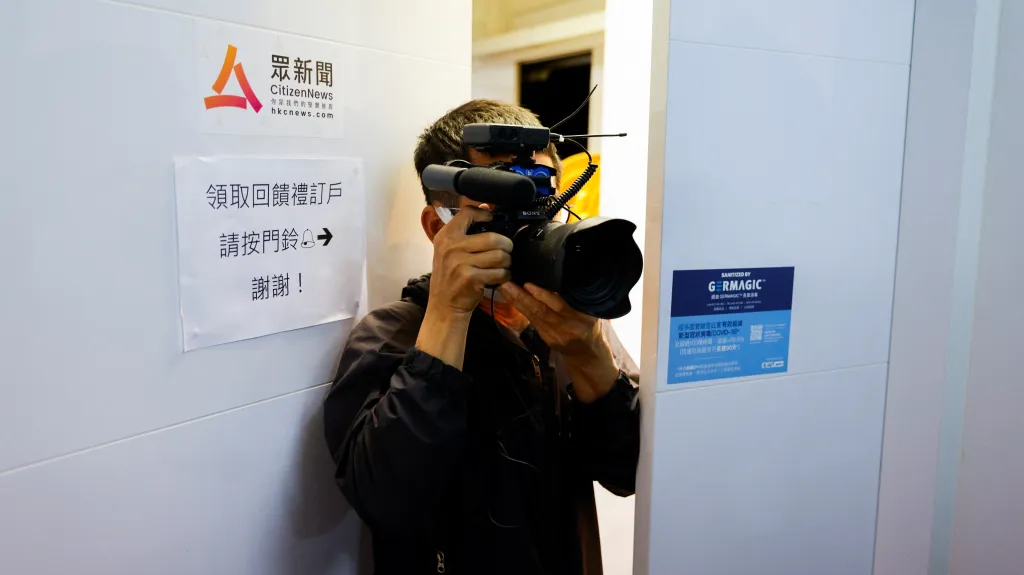 Novinář před dveřmi serveru Citizen News v Hongkongu