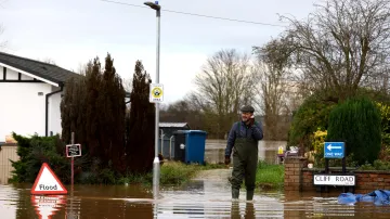 Muž prochází zatopenou ulicí v Redcliffu nad Trentem
