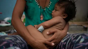 Estephanie se svým ročním dítětem z Hondurasu při odpočinku v mexickém městě Huixtla mezi tisíci dalších migrantů