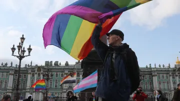 Muž mává duhovou vlajkou během shromáždění LGBT komunity v centru Petrohradu (snímek z roku 2019)