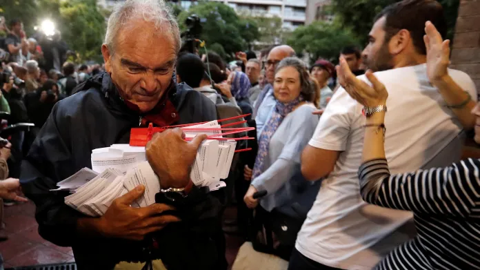 Muž drží hlasovací lístky v referendu o nezávislosti v Barceloně