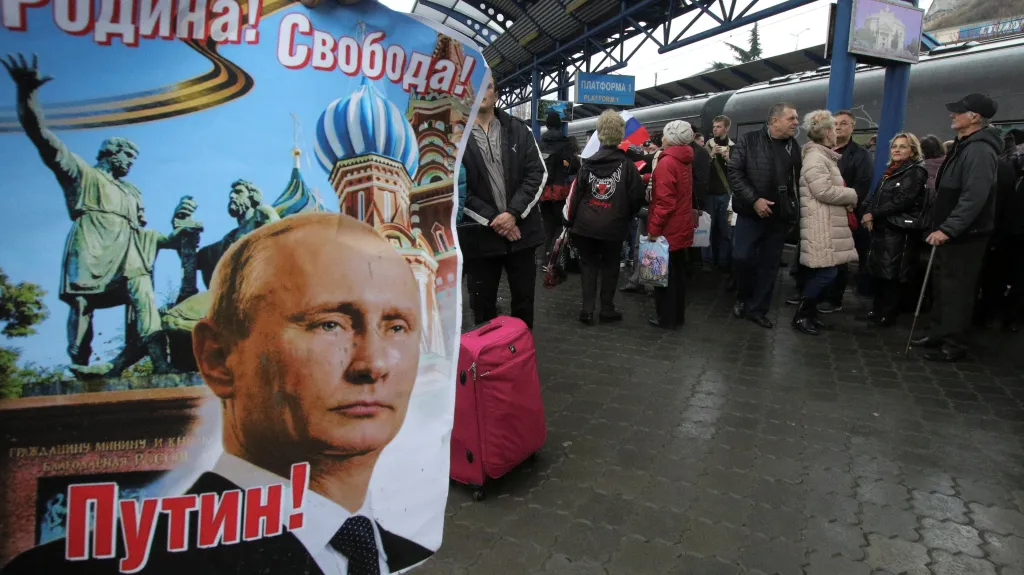 Vítání prvního vlaku z Ruska v okupovaném Simferopolu. Plakát nese nápis „Vlast! Svoboda! Putin!"
