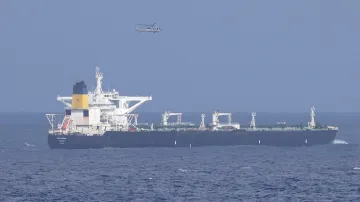 Ropný tanker plující pod panamskou vlajkou, nad kterým je vojenská helikoptéra Spojených států amerických, 21. prosince 2025