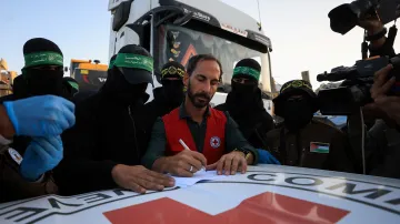 Člen Červeného kříže přebírá tělo, které bylo nalezeno palestinskými militanty z teroristického hnutí Hamás a Palestinského islámského džihádu, předtím než bude předáno Izraeli k určení, zda se jedná o tělo rukojmí, Pásmo Gazy, 3. prosince 2025