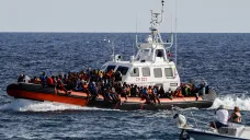 Člun italské pobřežní stráže se zachráněnými migranty u ostrova Lampedusa