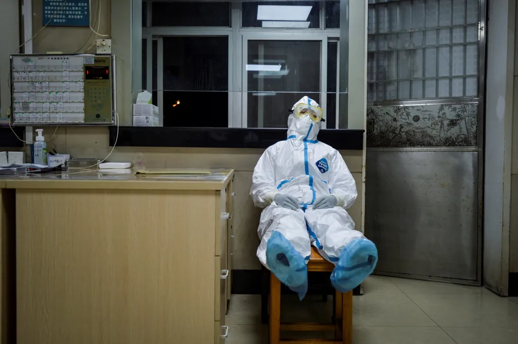 Lékařka v ochranném obleku si dopřává pauzu během noční směny ve zdravotním středisku v čínském Qingshanu