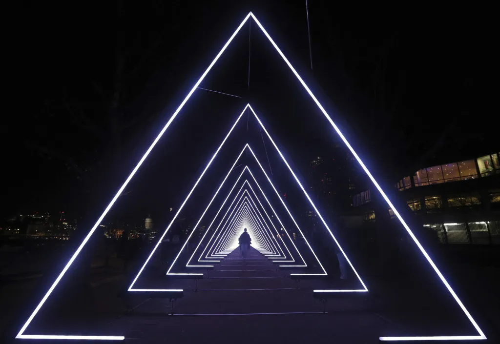 Lidé procházejí instalací s názvem Vlna závratě během Festivalu světla v Londýně.