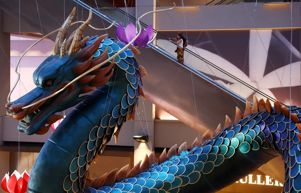 Čtyřicet metrů dlouhá socha draka visí ze střechy nákupního centra jako součást slavnostní výzdoby v Singapuru
