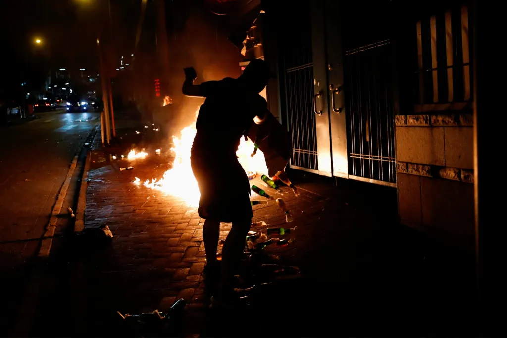Jeden z demonstrujících háže Molotovovy koktejly