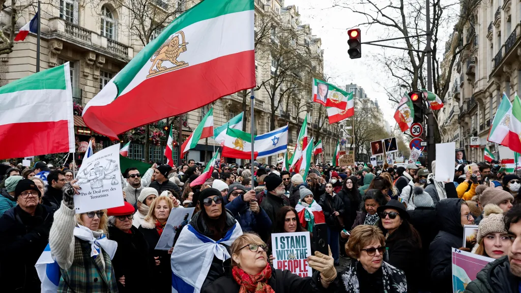 Demonstranti v Paříži během shromáždění na podporu íránského lidu drží vlajku z doby před íránskou revolucí