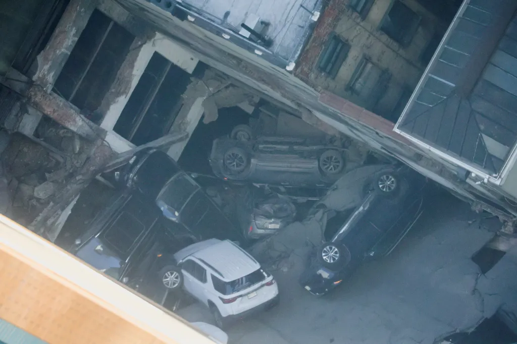 Několik zničených aut, která v budově parkovala