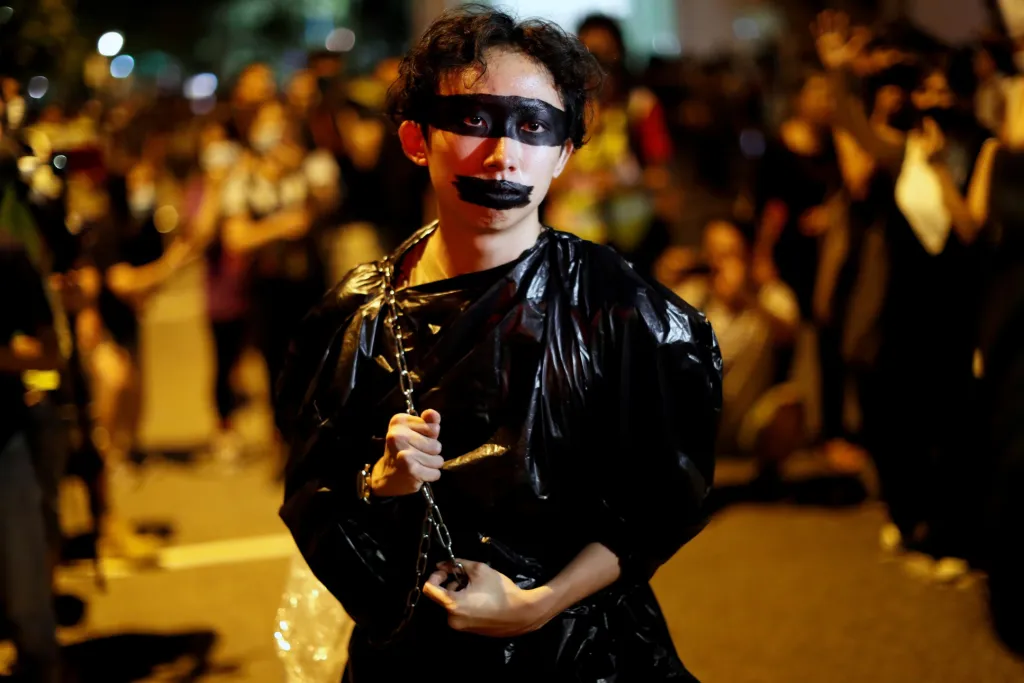 Čínské orgány zahájily jednání s protestujícími v Hongkongu. Jeden z místních umělců nese řetěz na místo prvního společného dialogu, kterého se účastnila šéfka hongkongské vlády Carrie Lamová