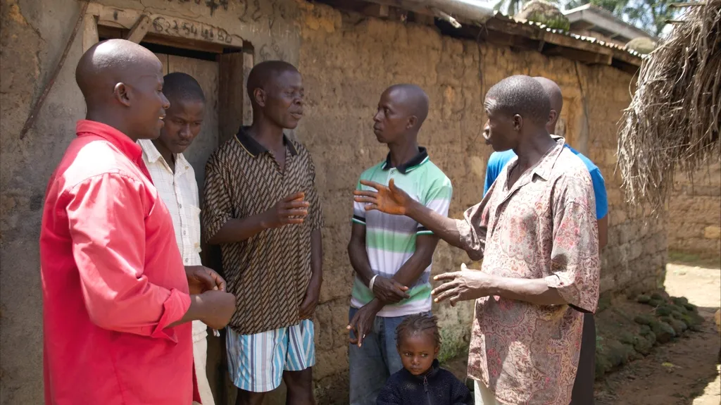 Starosta vesnice (třetí zleva) v diskuzi s místními