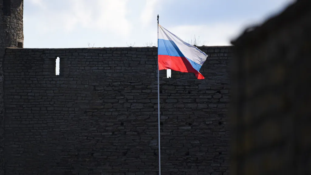 Ruská vlajka na pevnosti Ivangorod na estonsko-ruské hranici za řekou Narvou