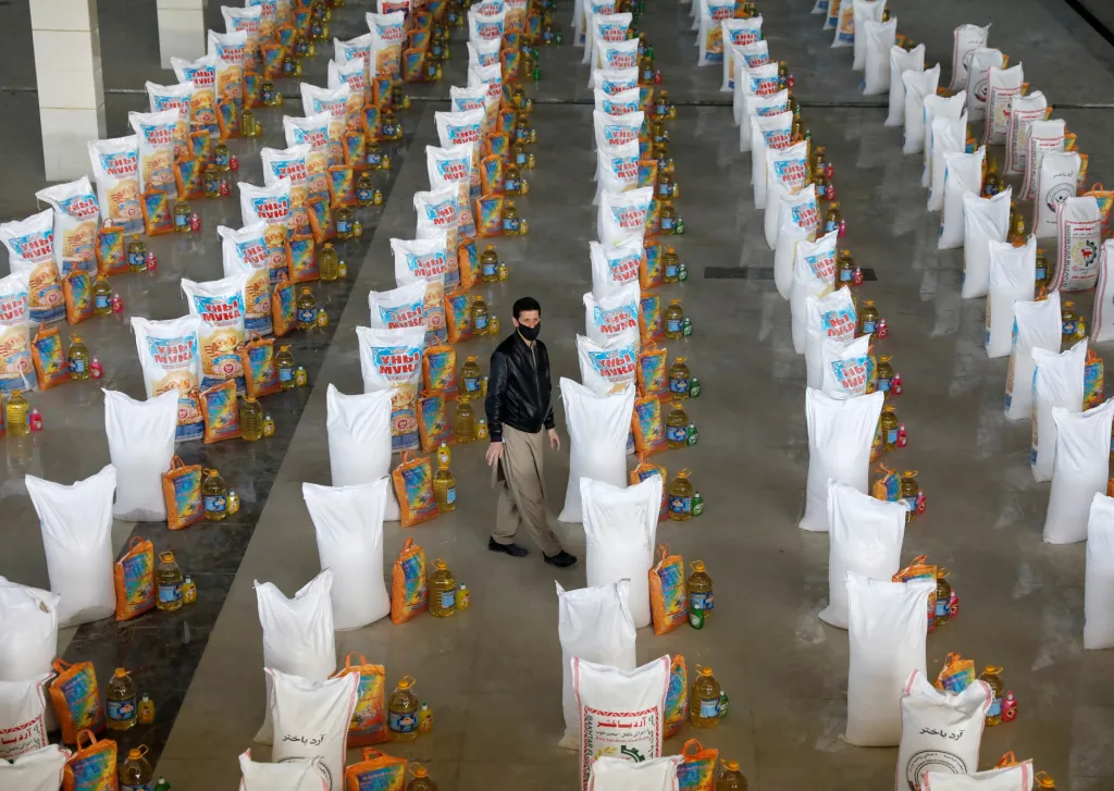 Pracovník skladu stojí mezi pytli potravinové pomoci pro hladem postižené lidi v Afghánistánu