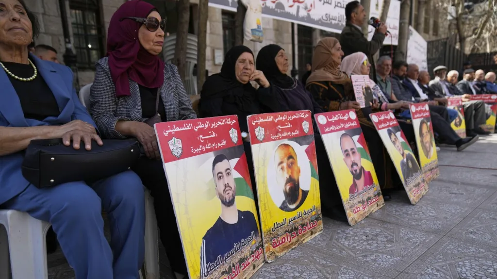 Lidé nesou plakáty s fotografiemi a jmény palestinských vězňů v Izraeli