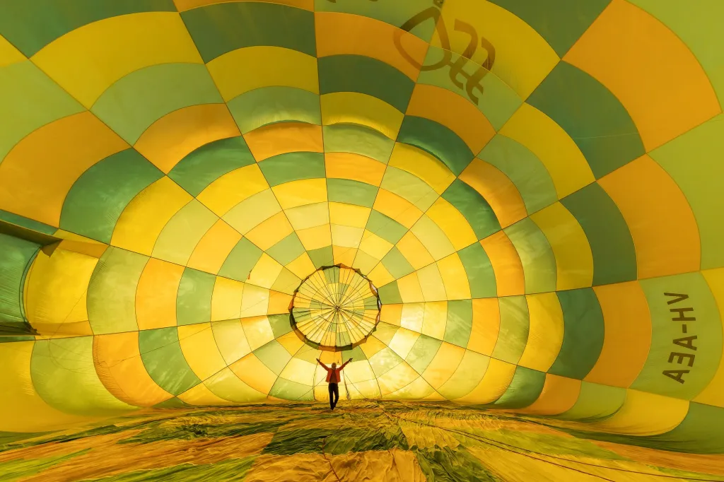 Žena v balonu není pilotkou ani účastnicí letecké show. Jde o australskou skokanku do vody Rhiannanu Ifflandovou.  Fotografie ukazuje přípravu před extrémním skokem do vody přímo z letícího balonu. Rhiannana je několikanásobná světová šampionka v této neobvyklé disiciplíně