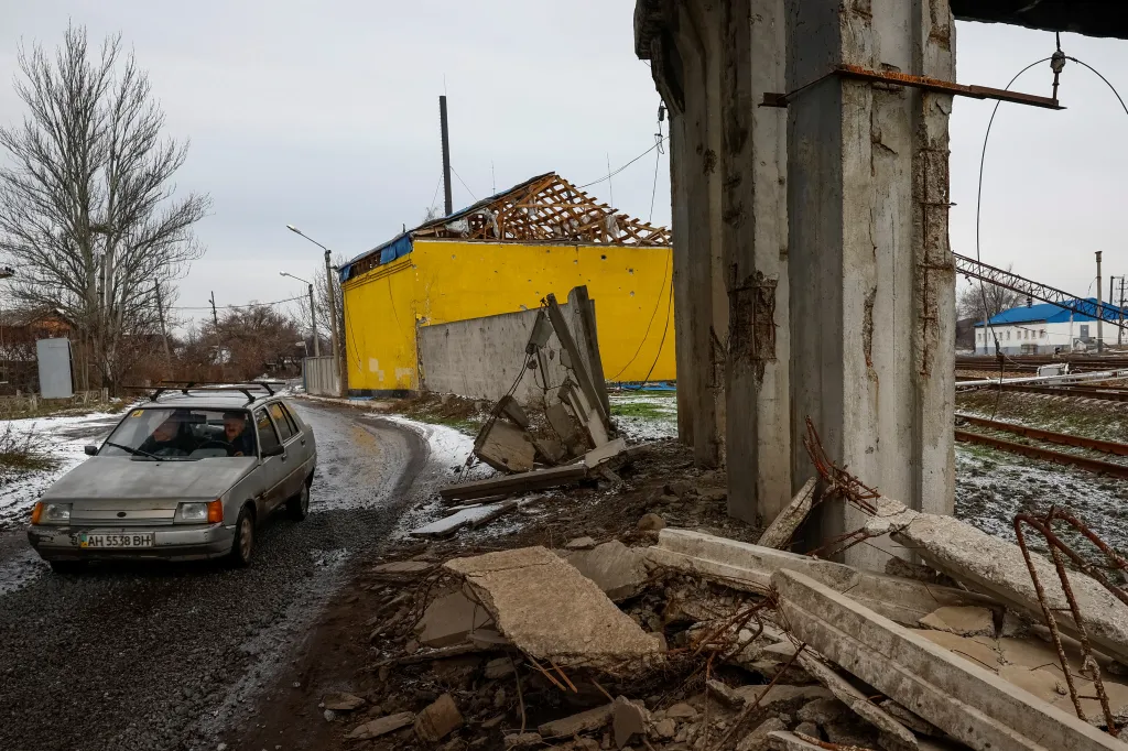 Auto projíždí pod poničeným mostem v Pokrovsku