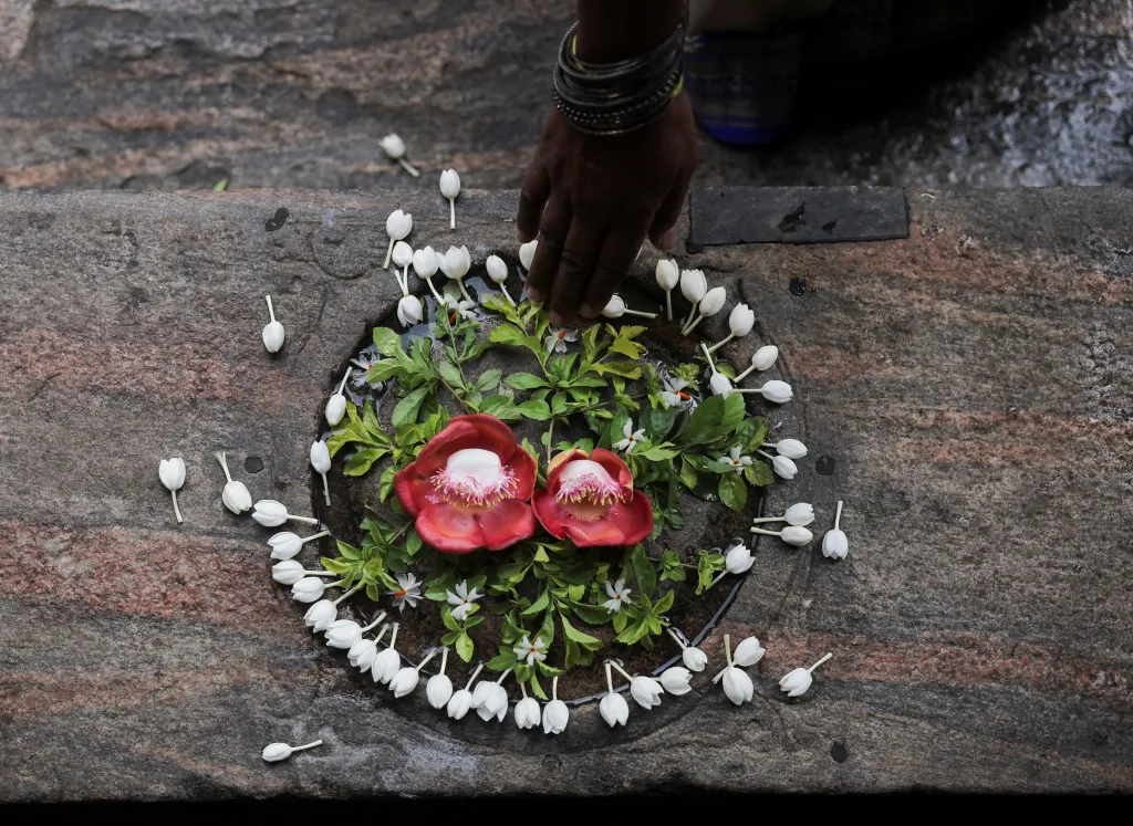 Věřící se dotýká zdobeného schodu před vstupem do chrámu