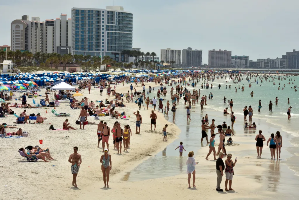 Během chvil, kdy si lidé užívali odpočinek na pláži, se americké vládní orgány snažily prosadit omezení pohybu osob v souvislosti s onemocněním COVID-19. Vyfoceno na Floridě 17. března 2020