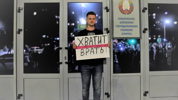 Demonstrant s nápisem "dost bylo lhaní" před sídlem běloruské televize