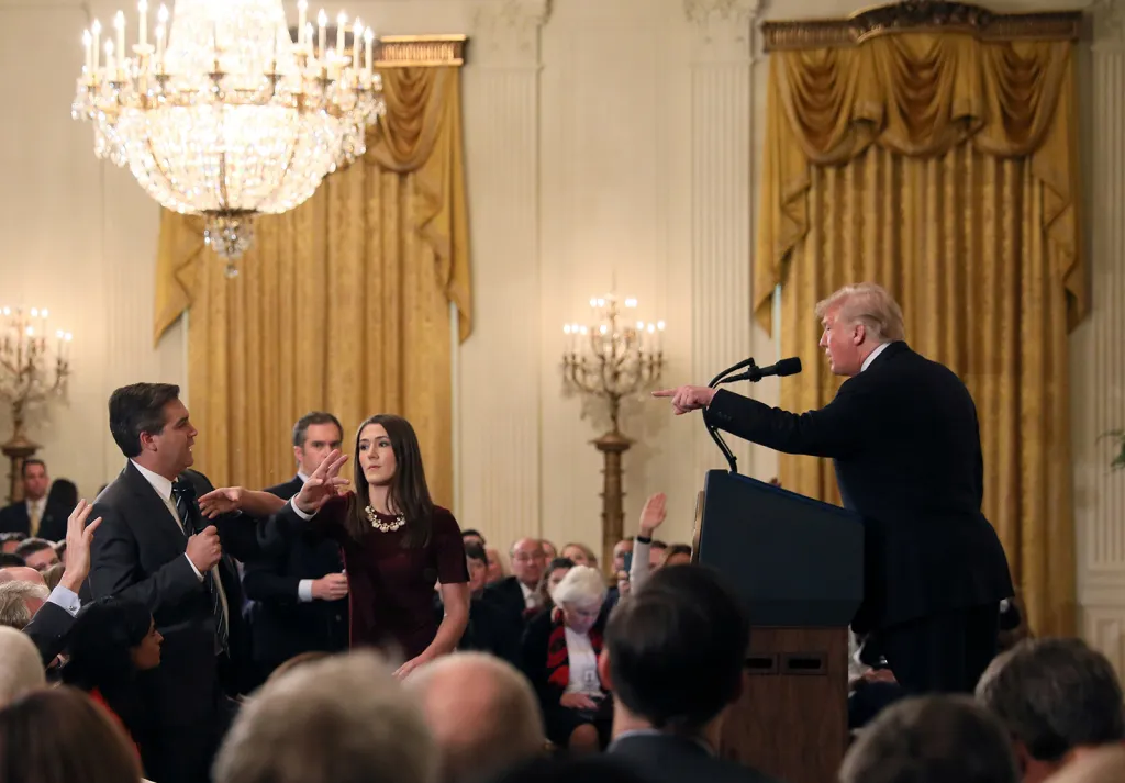 Zaměstnankyně Bílého domu se marně snaží odebrat mikrofon novináři stanice CNN Jimimu Acostovi, který se na tiskové konferenci dotazoval prezidenta Trumpa na karavanu migrantů. Trump ho následně označil za příšerného člověka, za kterého by se měla CNN stydět.