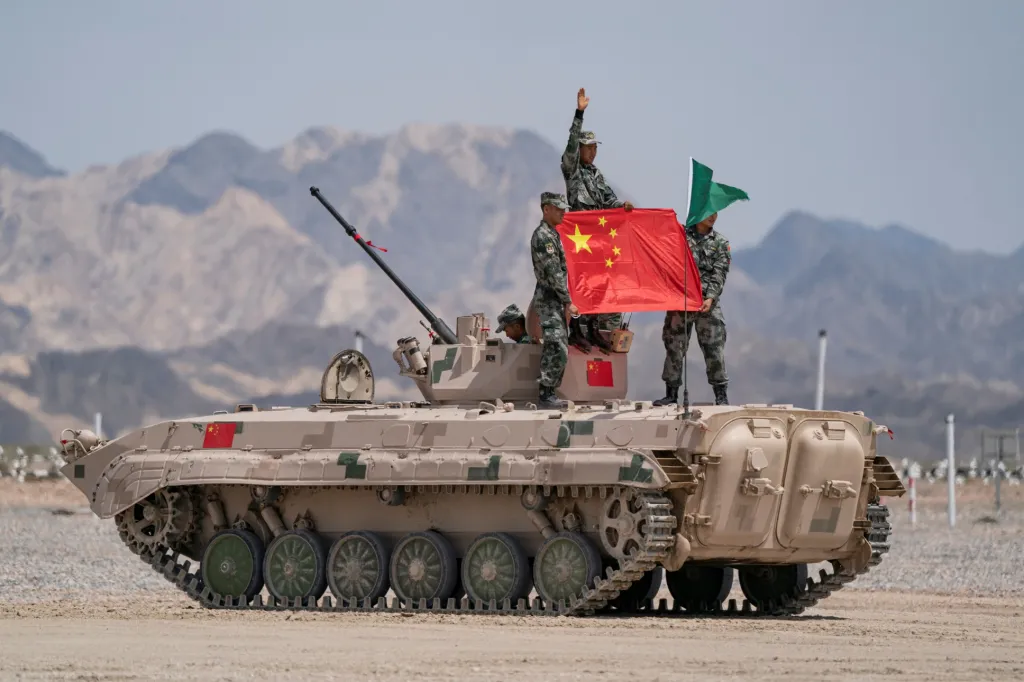 Vojáci čínské armády po soutěži nazvané Suvorov Attack pózují se svojí vlajkou