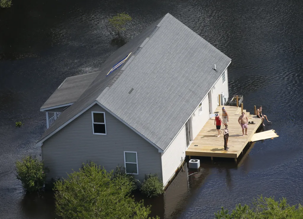 Obyvatelé zatopených oblastí kolem města Burgaw v Severní Karolině mávají na záchranářskou helikoptéru uvězněni povodněmi způsobenými hurikánem Florence