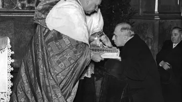 Emil Hácha v Chrámu svatého Víta líbá lebku svatého Václava v rukou kardinála Karla Kašpara. Snímek z 1. prosince 1938.