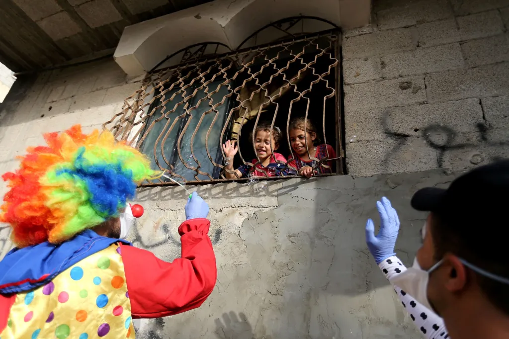Klauni v Chán Júnisu v Pásmu Gazy baví na ulici děti, které jsou omezené zákazem pohybu kvůli možné nákaze novým koronavirem