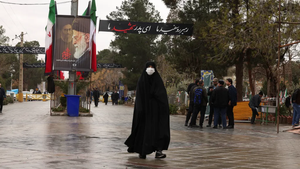 Íránka míří během války na hřbitov v Teheránu