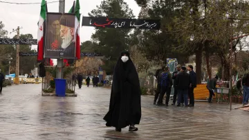 Íránka míří během války na hřbitov v Teheránu