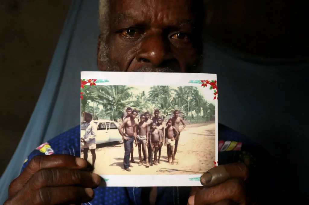 „Je to smutná vzpomínka. Kamarády už nemám a palmy odneslo moře,“ říká Assah Kokou Akpebiotor (70), když drží fotografii pořízenou před 45 lety a ukazuje na ní sebe a kamarády stojící před kokosovými palmami
