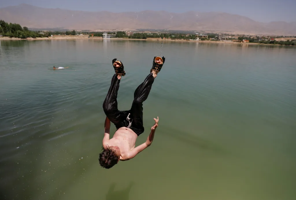Chlapec se baví skoky do vody u jezera Qargha