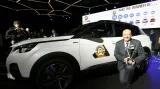 Jean-Philippe Imparato, ředitel automobilky Peugeot, pózuje s cenou Auto roku 2017 před vítězným vozem SUV Peugeot 3008.
