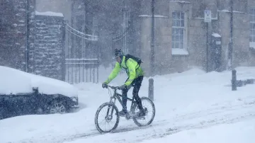 Cyklista sjíždí kopec pod hradem Sterling ve Skotsku