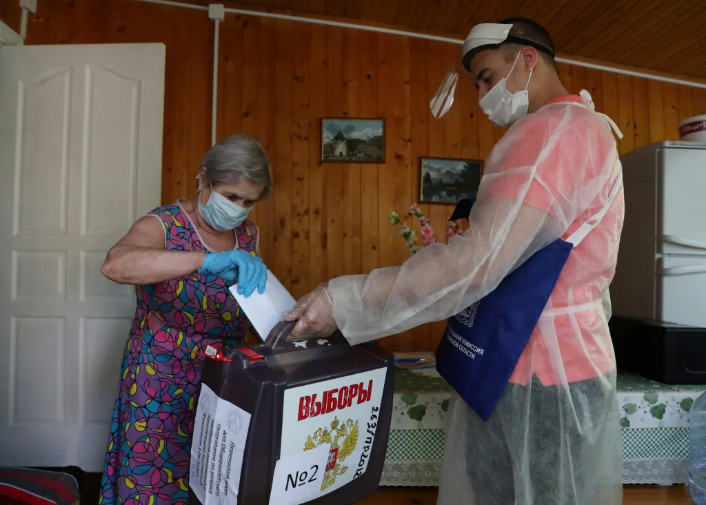 Žena odevzdává hlasovací lístek do mobilní schránky členů volební komise ve vesnici Lutsino v Moskevské oblasti. Sedmidenní hlasování má rozhodnout o ústavních reformách v Rusku