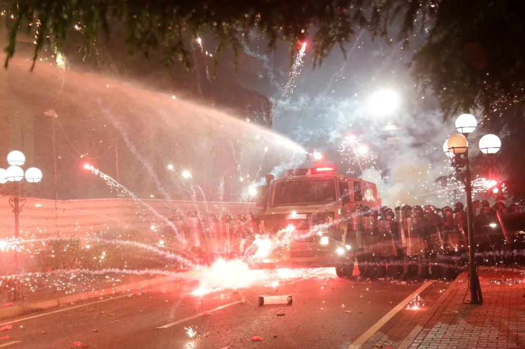 Protivládní albánští demonstranti házejí světlice na policii během protestu v Tiraně