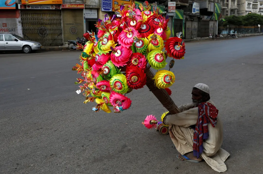 Prodavač papírových kytek v Pákistánu čeká před mešitou na děti, které se účastní modlitby
