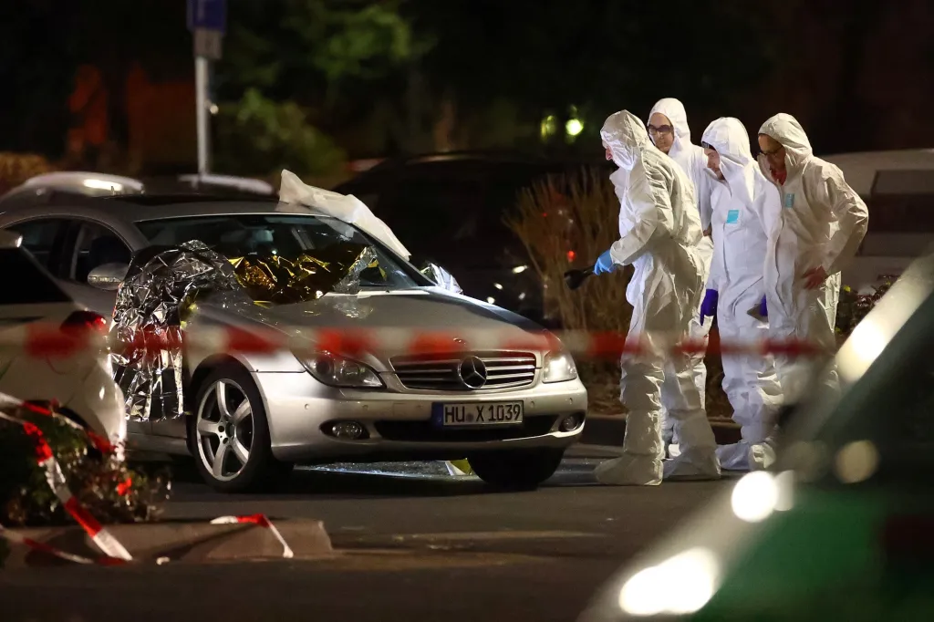 Forenzní experti prohlížejí poničený automobil po střelbě v německém Hanau nedaleko Frankfurtu