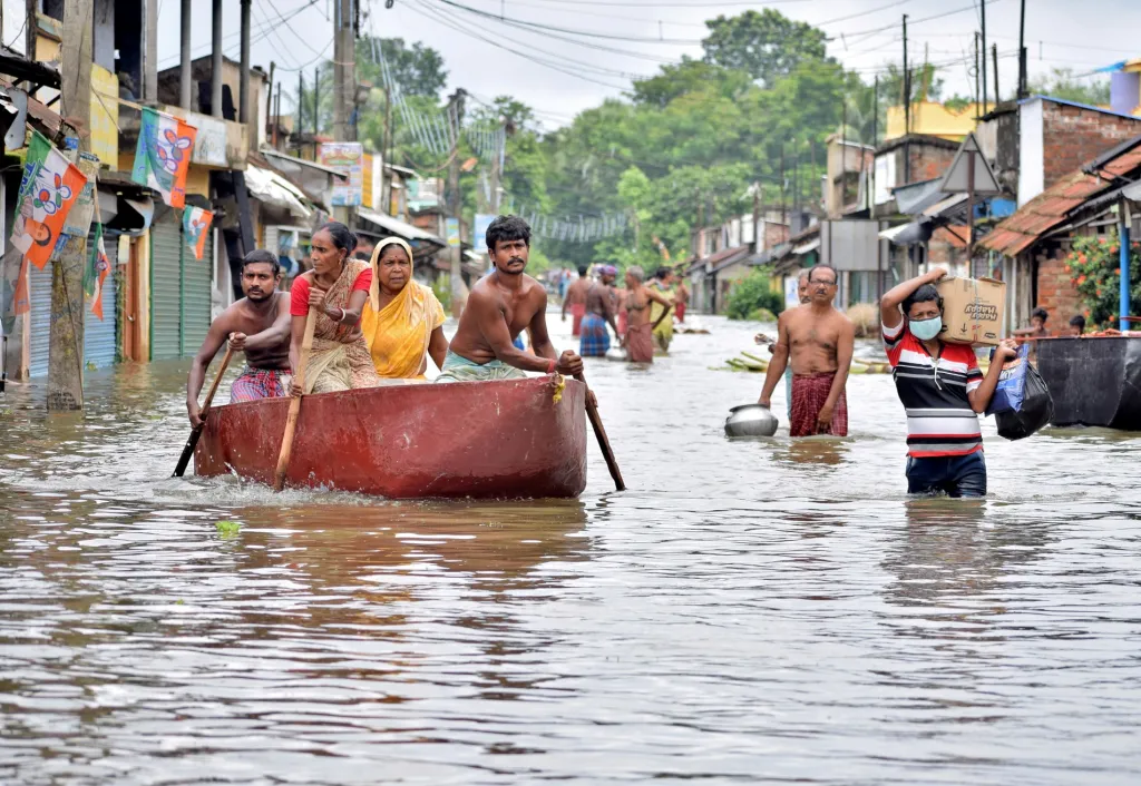 Lidé se brodí zaplavenou ulicí, aby sehnali potraviny a pitnou vodu v centru města Amta v indickém státě Západní Bengálsko, které bylo ve čtvrtek zasaženo povodní