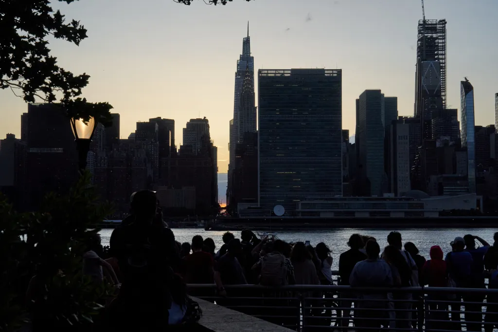Lidé sledují západ slunce nad newyorským Manhattanem