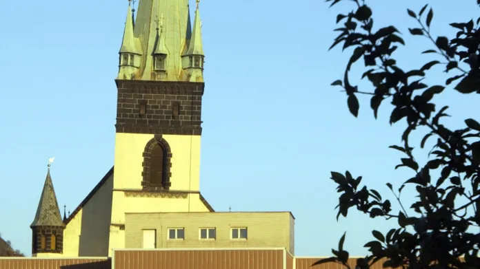 Věž kostela Nanebevzetí panny Maria za dnes již nestojící budovou tržnice na snímku z roku 2004