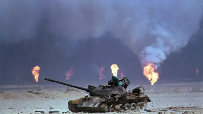 Zničený irácký tank během války v Perském zálivu, v pozadí hoří ropná pole