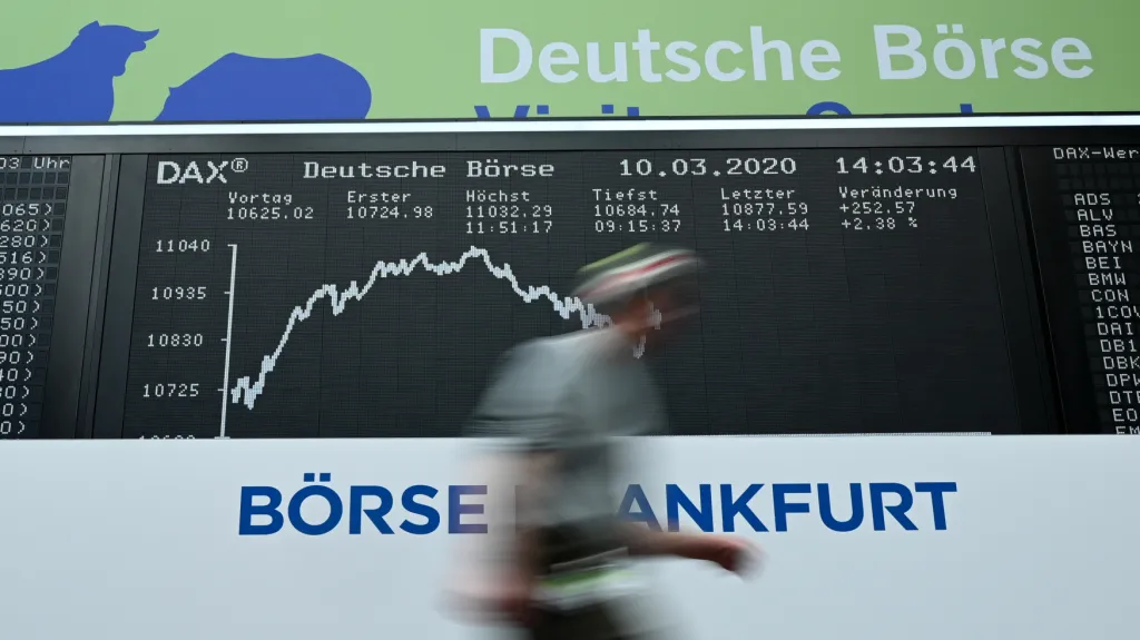 Muž prochází kolem tabule s indexem DAX frankfurtské burzy