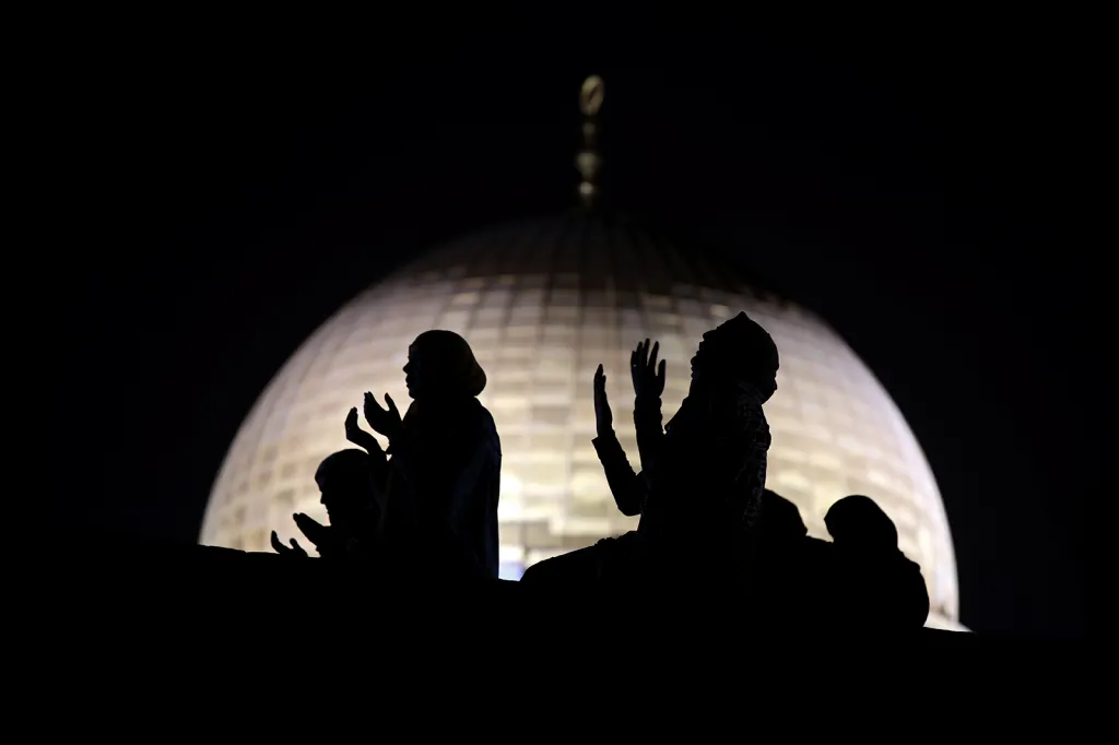Muslimské ženy při modlitbě u Skalního Dómu v místě známém muslimům jako Vznešená a ušlechtilá svatyně a Židům jako Chrámová hora během islámského svátku Laylat al-Qadr